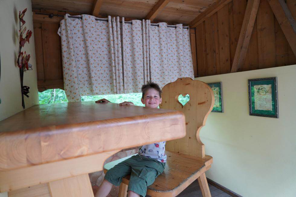 Kind auf einem riesigen Stuhl an einem riesigen Tisch