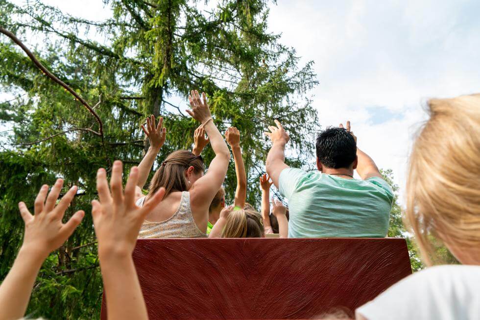 Besucher auf einer Achterbahn im Freizeitpark Märchenwald